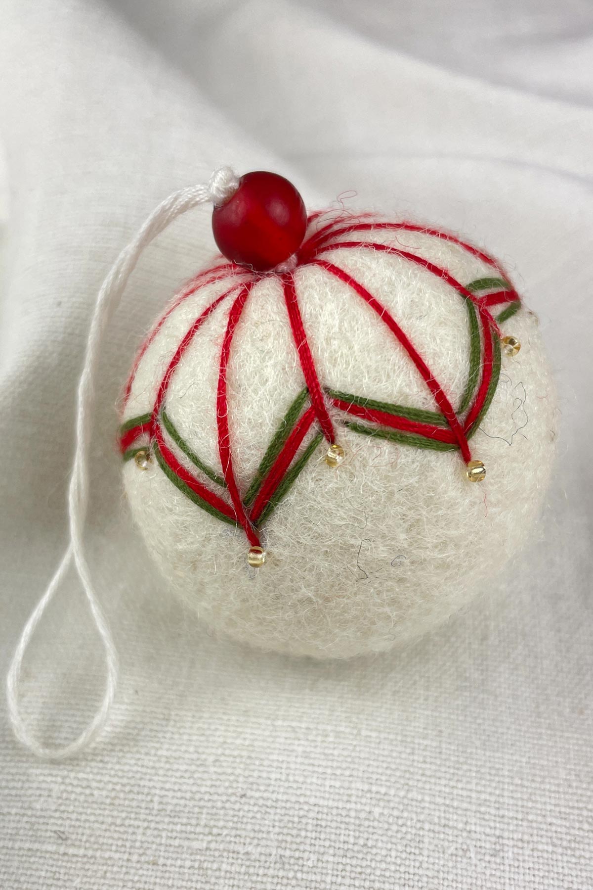 Close-up of beads on felt bauble in cream