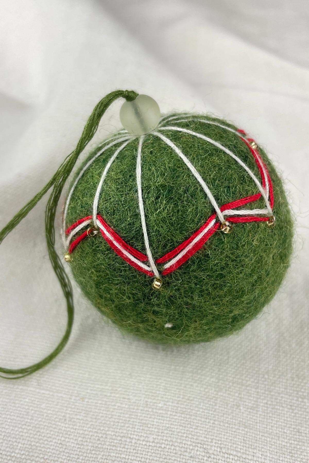 Close-up of beads on felt bauble in ivy green