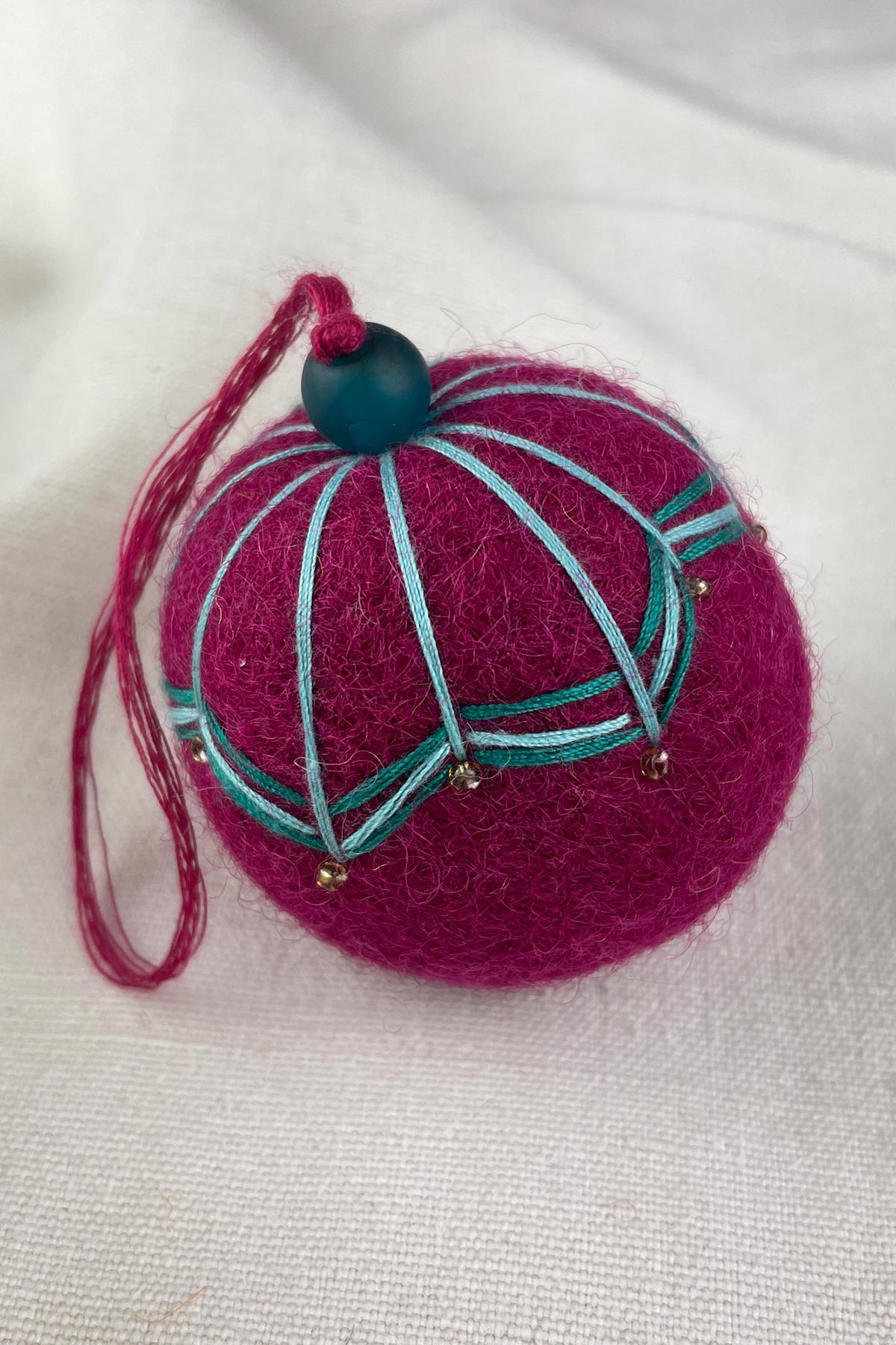 Close-up of beads on felt bauble in raspberry pink