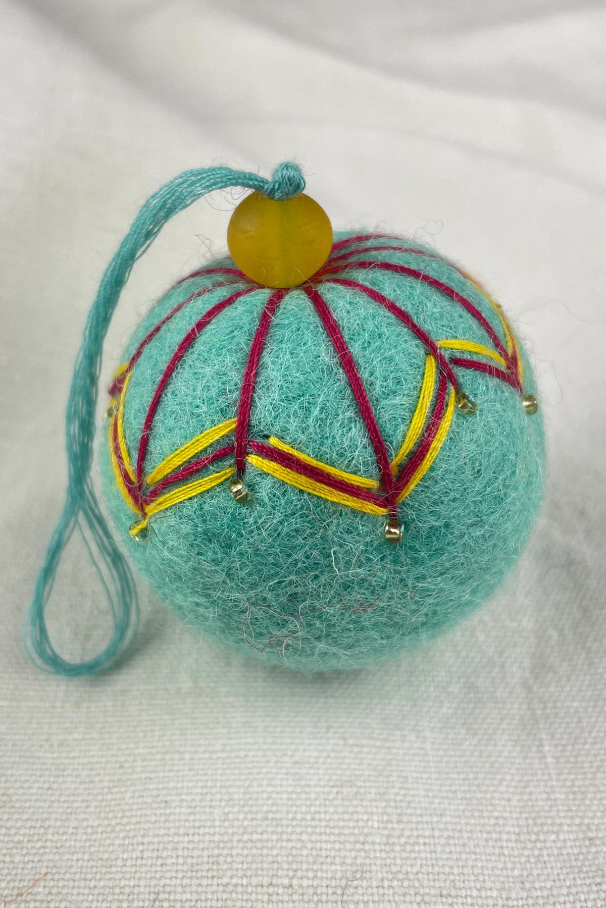 Close-up of beads on felt bauble in sea glass green