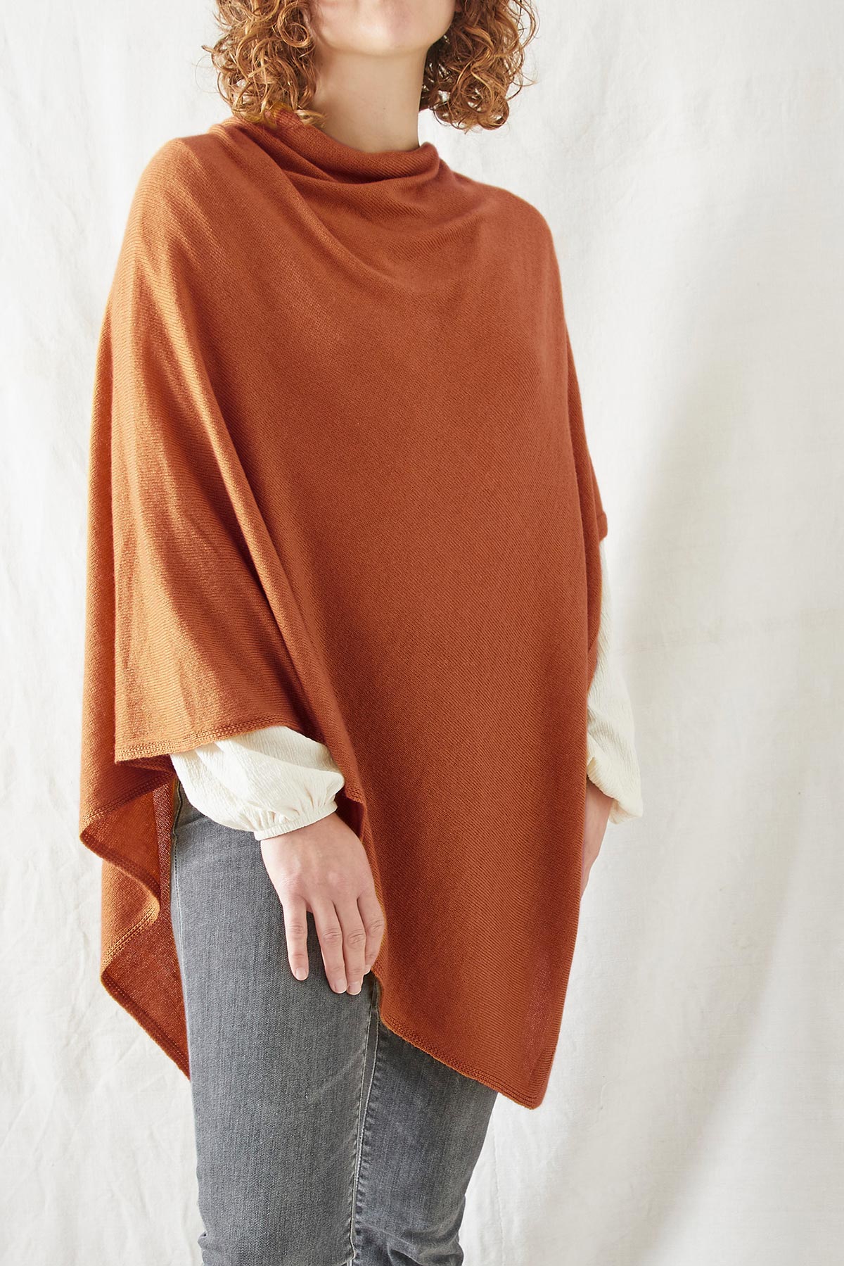 Model wearing Risi merino poncho in burnt orange
