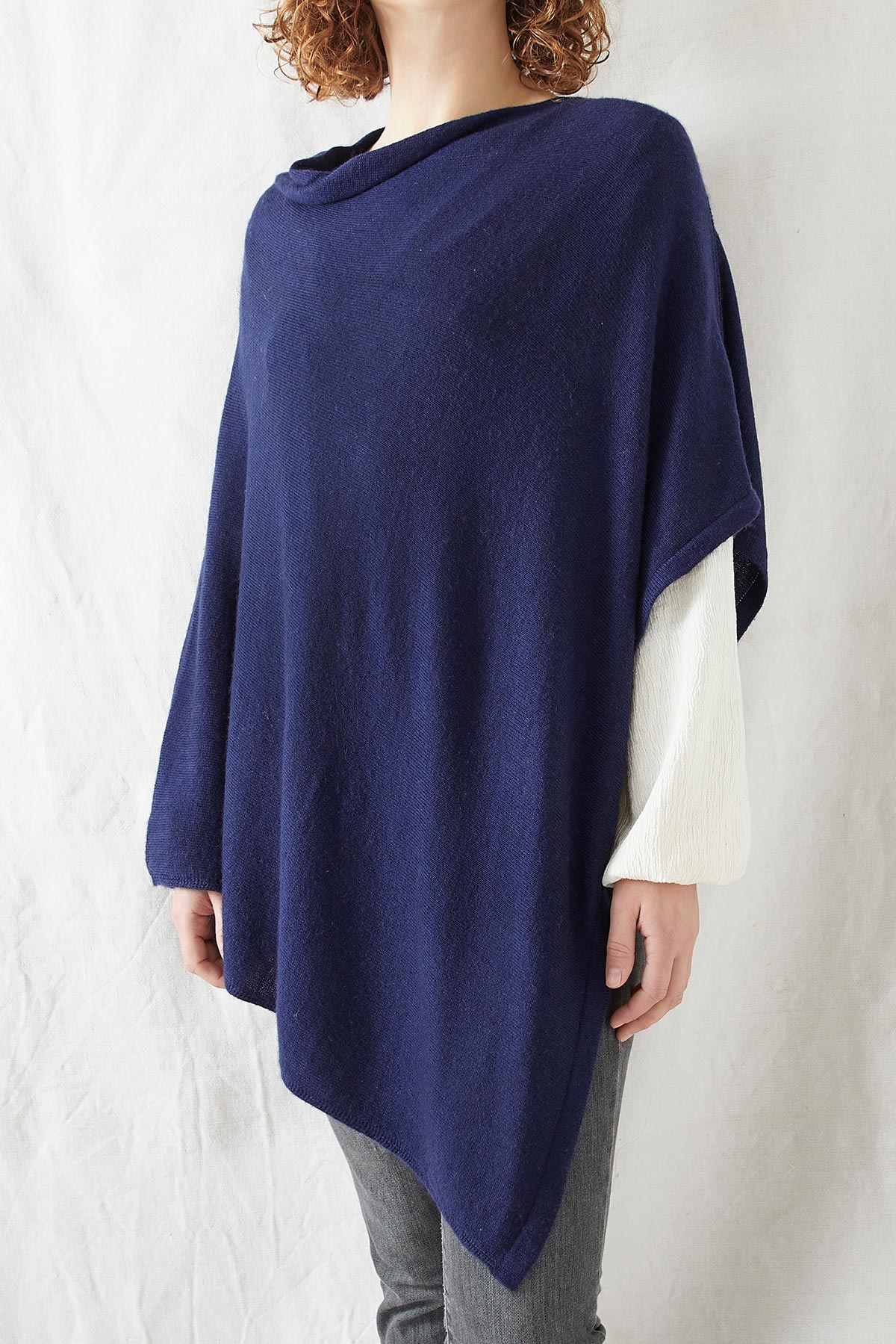 Model wearing Risi merino poncho in navy blue