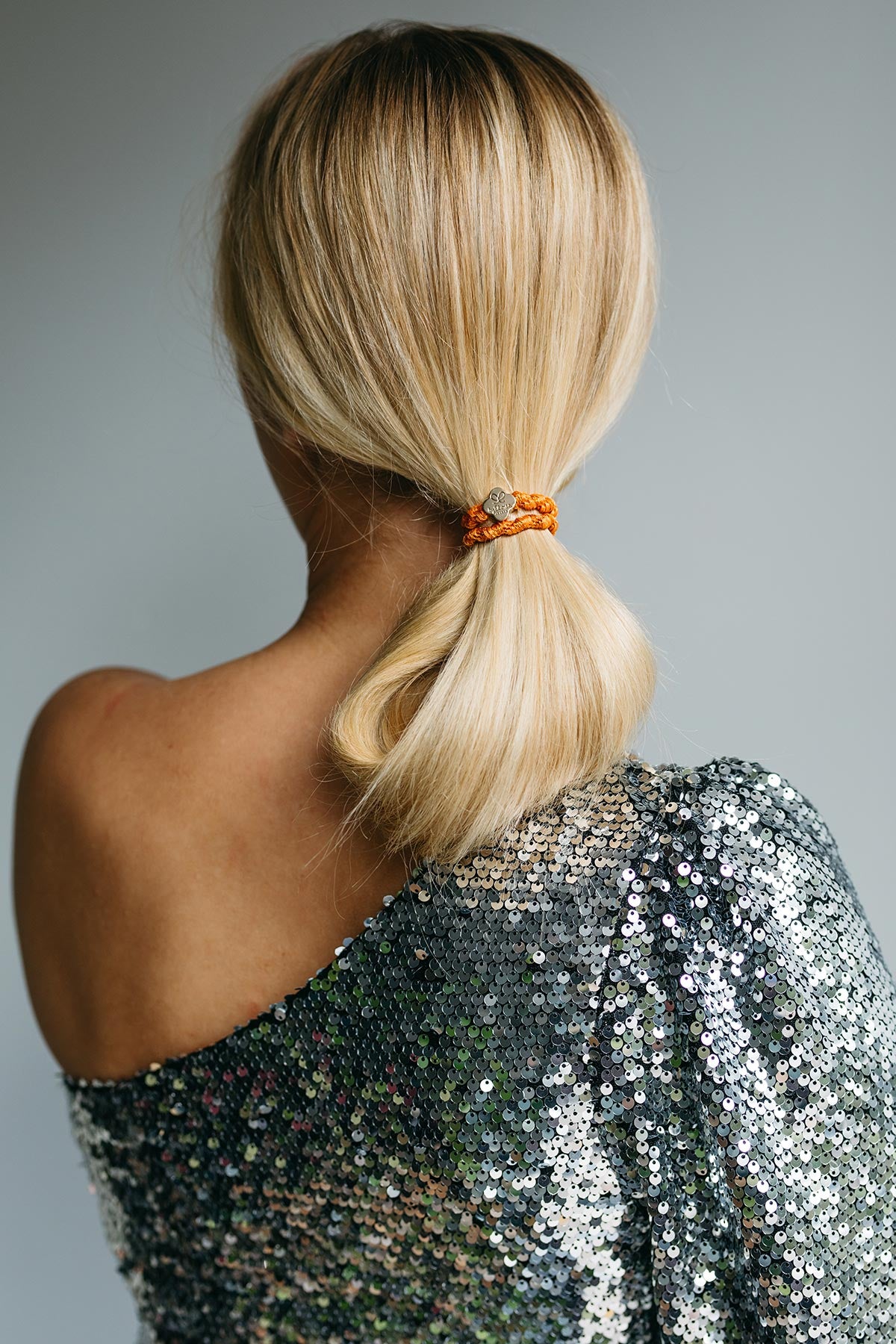 Close-up of By Eloise saffron woven Bangle Band with gold quatrefoil charm