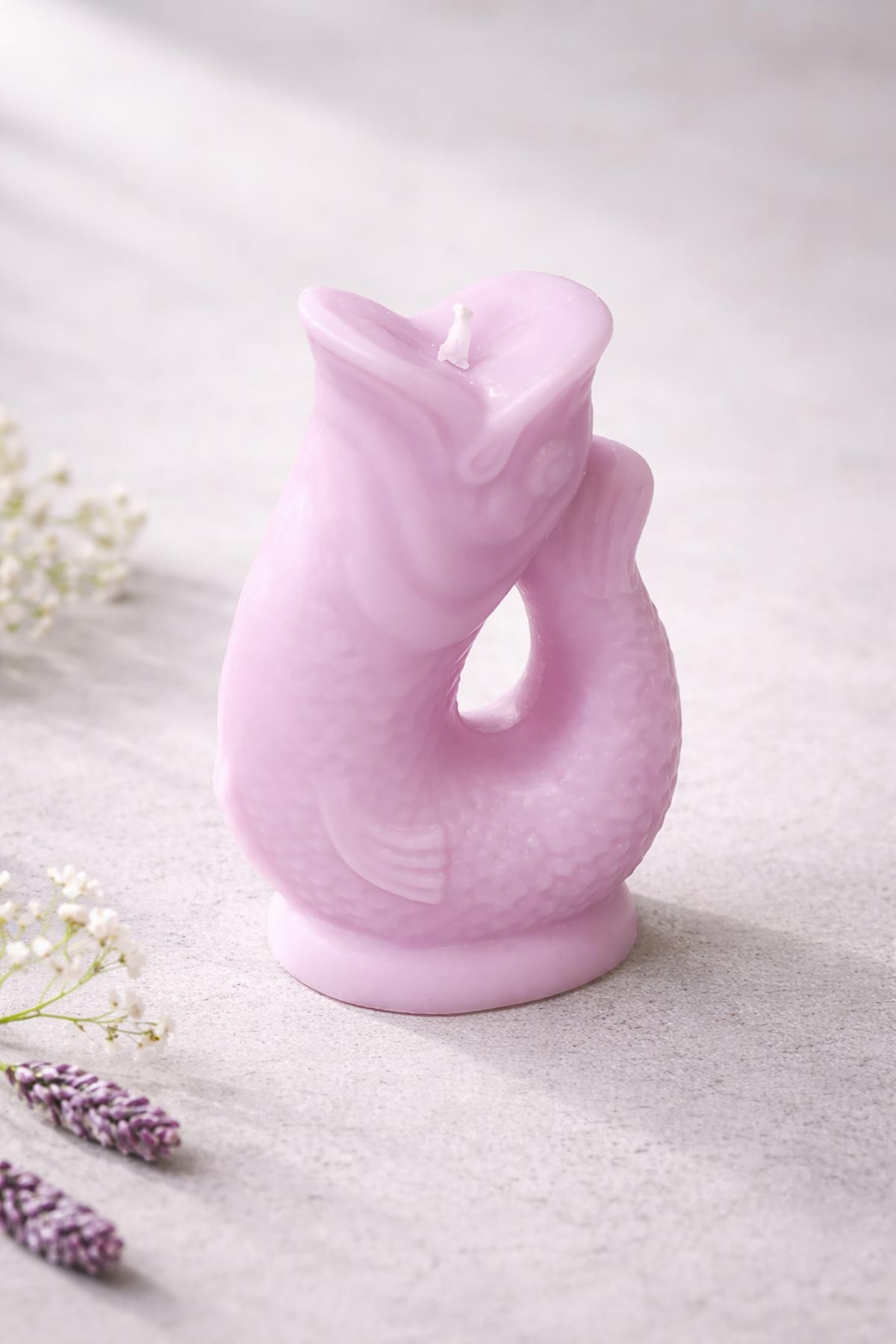 Side view of lilac Gluggle Jug Candle with sculptural fish shape