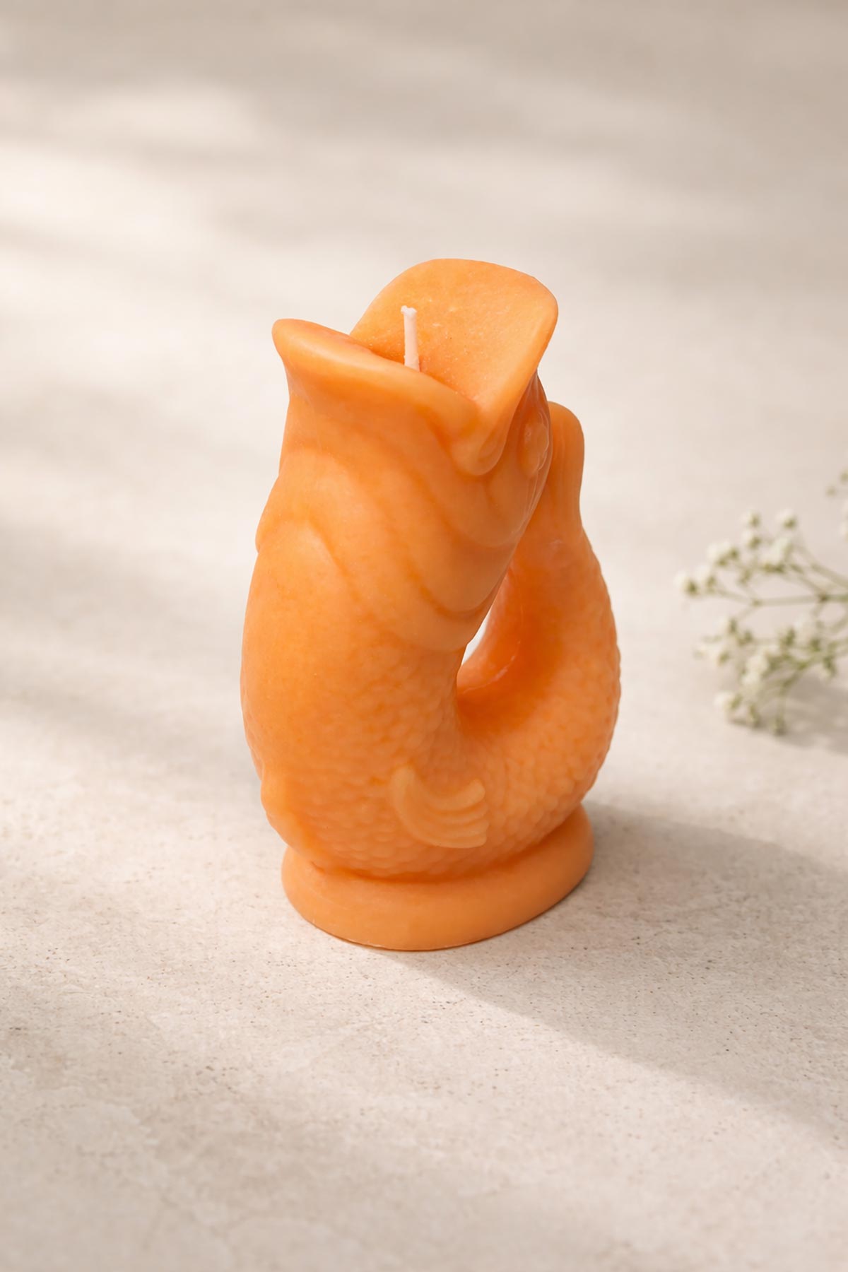 Side view of orange Gluggle Jug Candle with sculptural fish shape