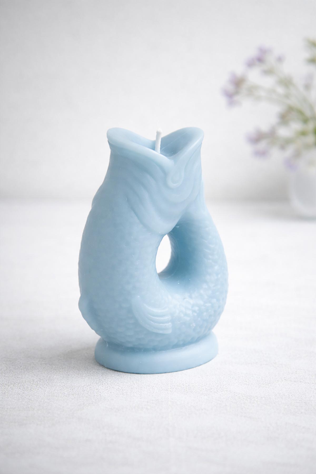 Side view of powder blue Gluggle Jug Candle with sculptural fish shape