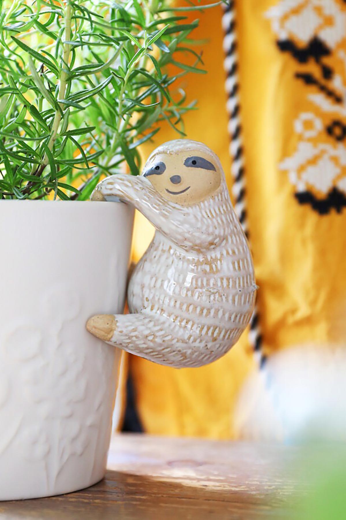 Sloth hanger draped over plant pot