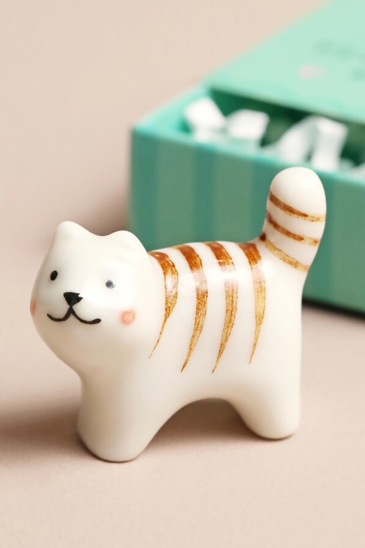 Ceramic cat token displayed outside matchbox