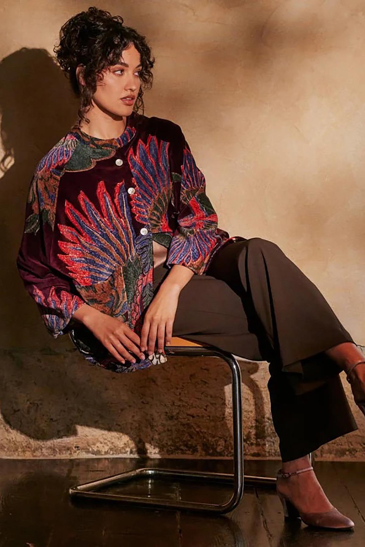 Model wearing Crane Plum Velvet Jacket sitting