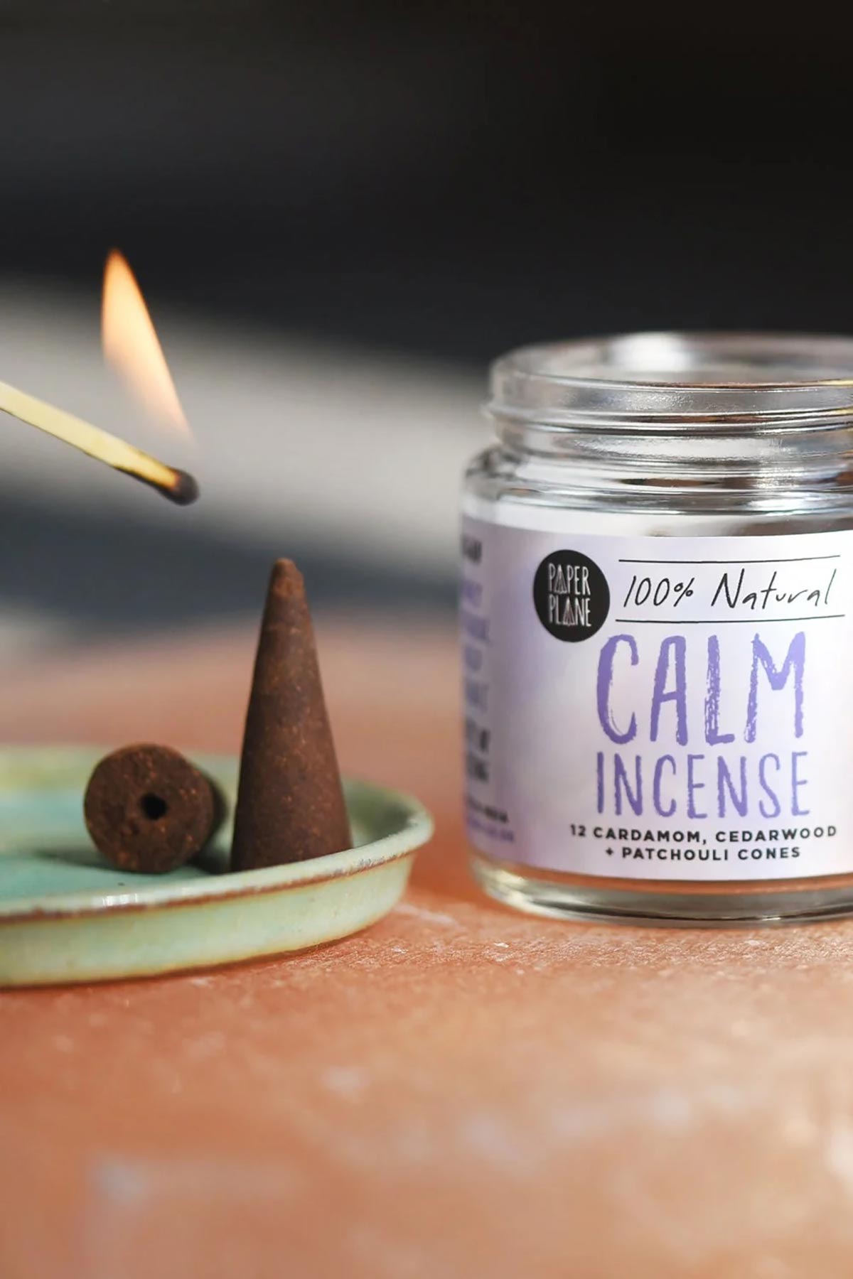 Paper Plane Calm natural incense cone being lit on a green ceramic dish — Urban Wild