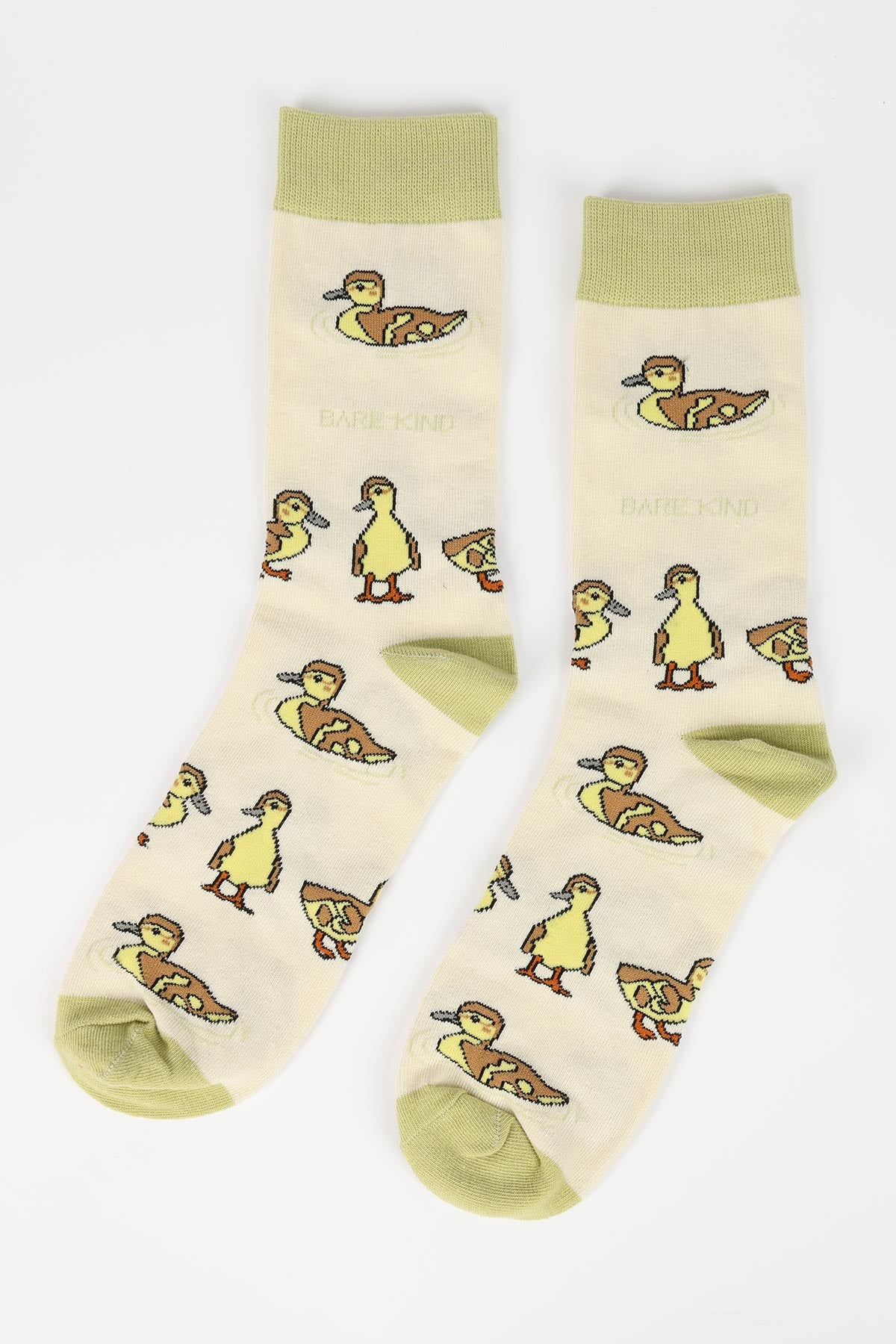 Pair of cream bamboo crew socks with all-over duckling print and sage green trim flat lay — Urban Wild