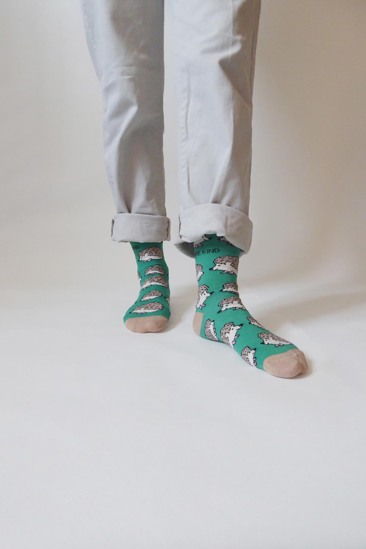 Green bamboo hedgehog crew socks worn with rolled cream trousers — Urban Wild