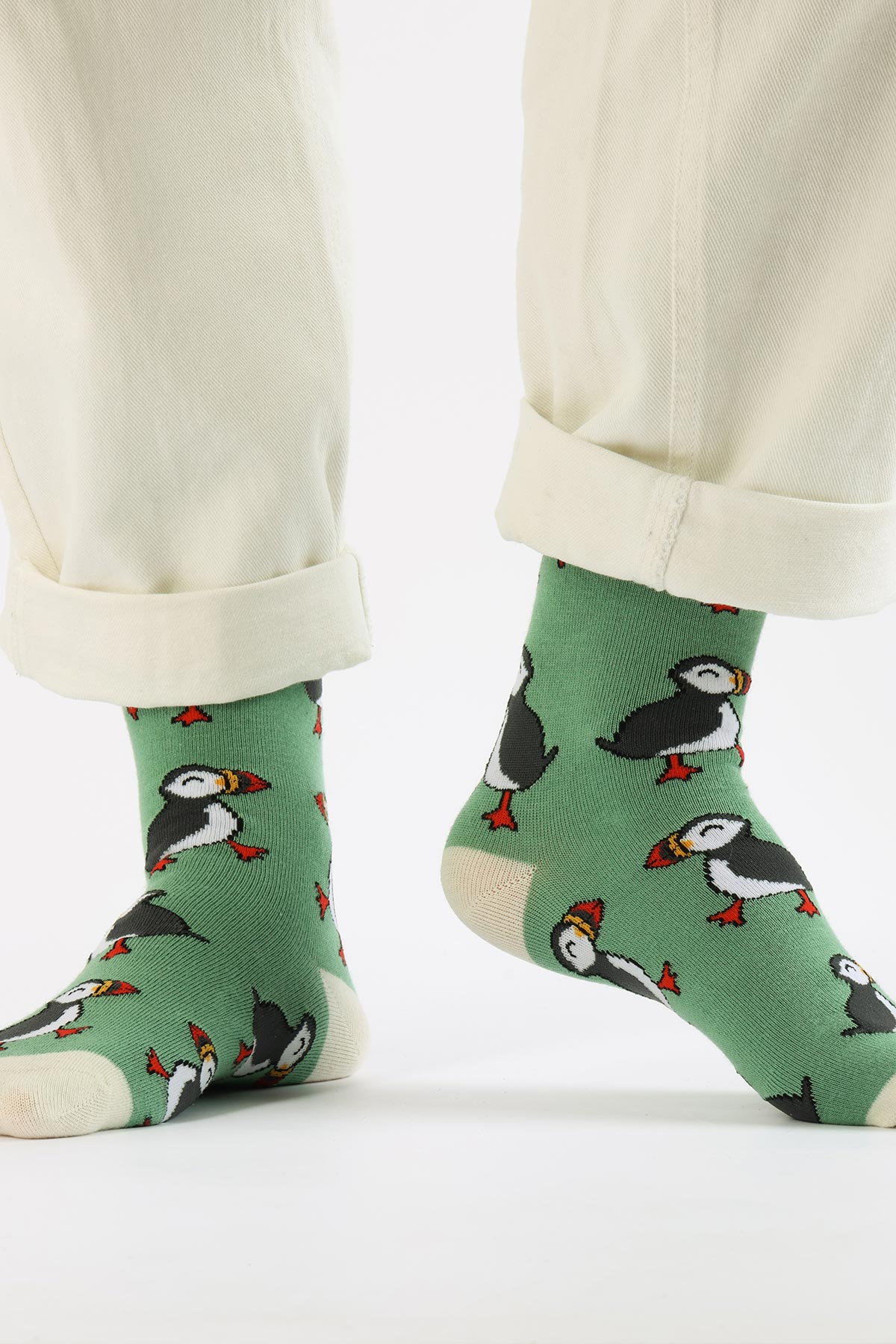 Green puffin bamboo crew socks worn with cream trousers, cream cuffs and heels — Urban Wild
