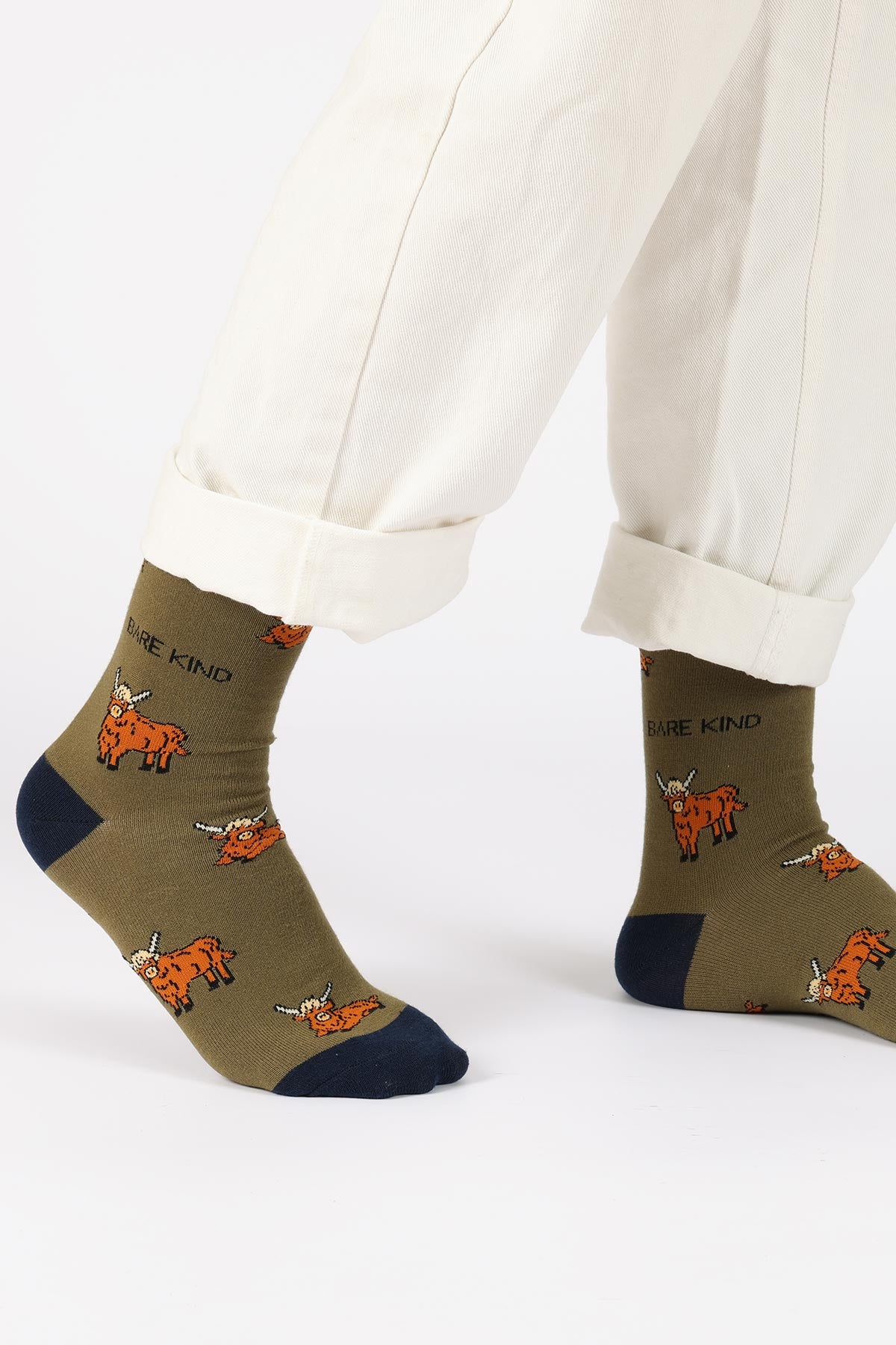 Khaki green Highland cow bamboo crew socks styled with cream trousers — Urban Wild