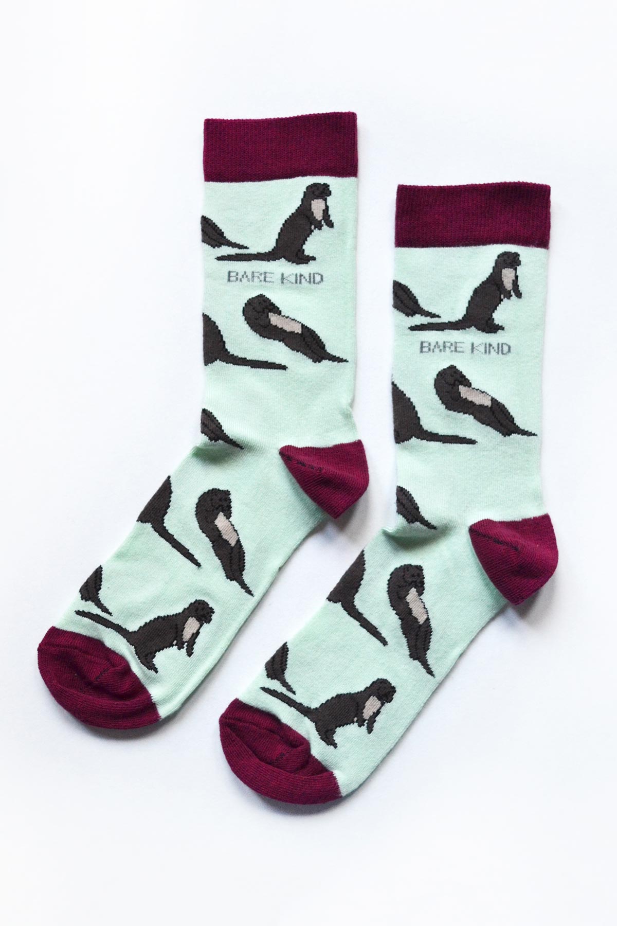 Pair of mint green bamboo crew socks with brown otter motif and burgundy heel — Urban Wild