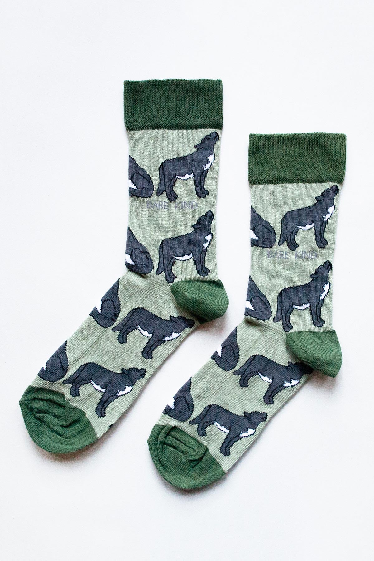 Pair of green bamboo wolf crew socks flat lay with charcoal wolf motifs — Urban Wild