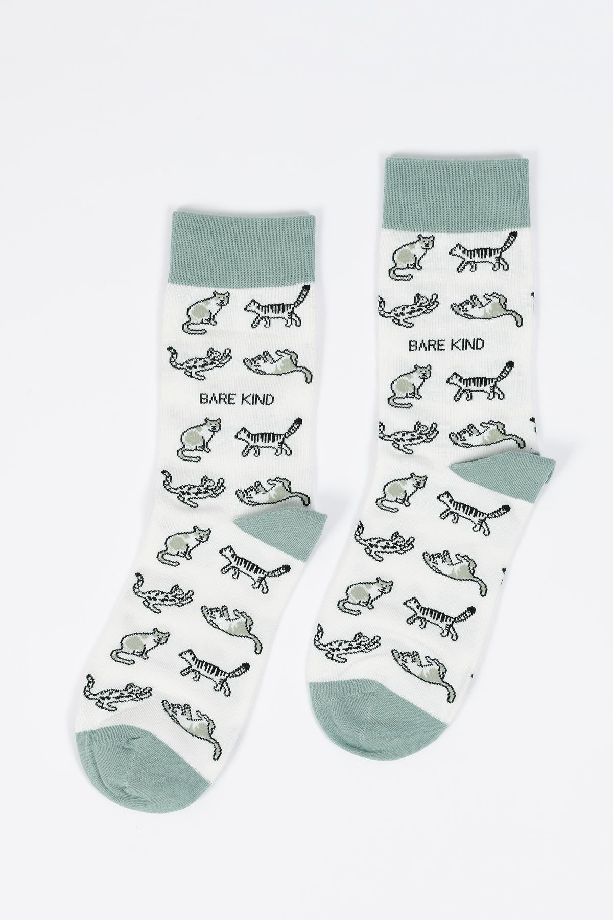 Flat lay of white bamboo crew socks with sage cuff and all-over wild cat motif — Urban Wild