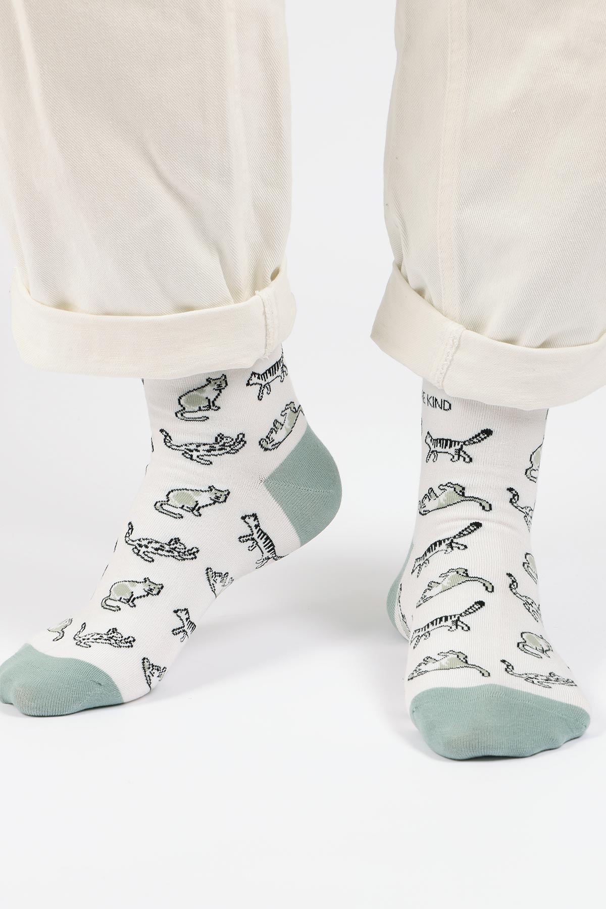 White and sage bamboo crew socks with wild cat print worn with cream trousers — Urban Wild