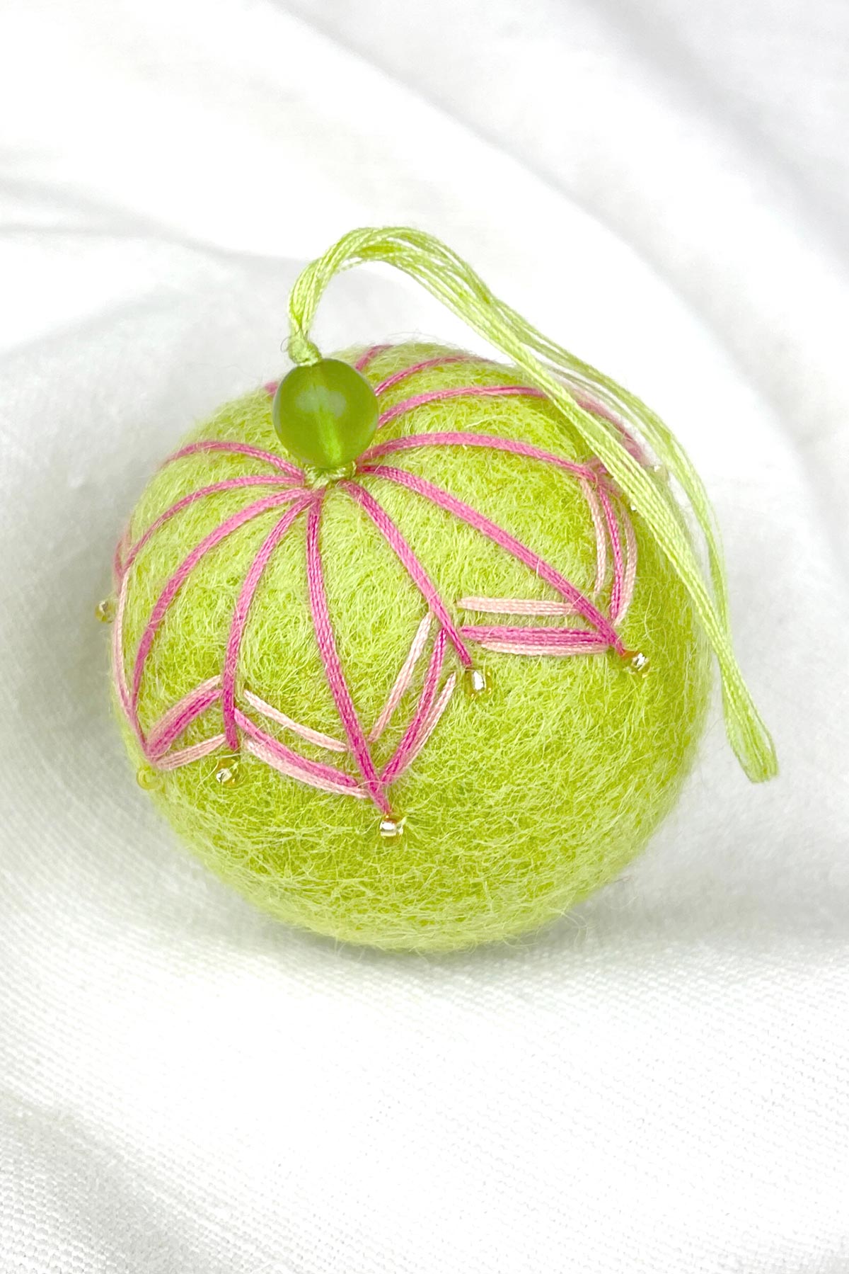 Close-up of beads on felt bauble in orange mango green tea