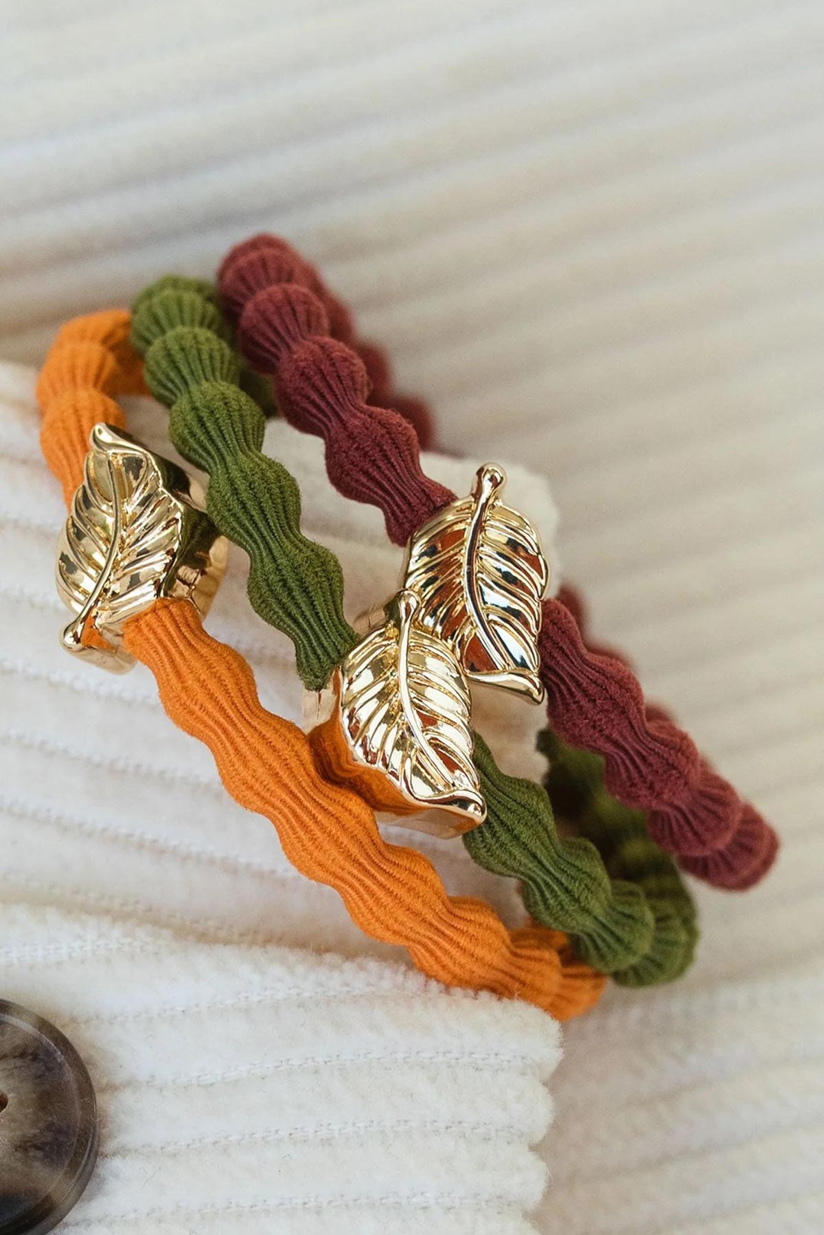 Close-up of By Eloise amberglow Bangle Band with gold leaf charm