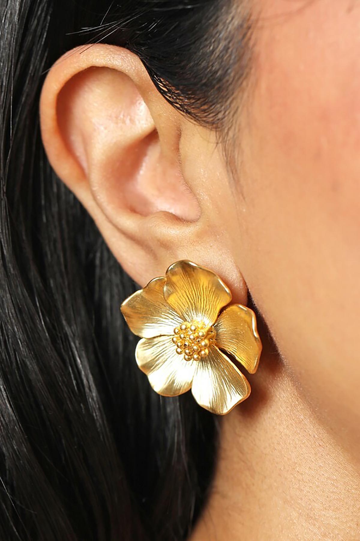 Close-up of gold flower stud earrings