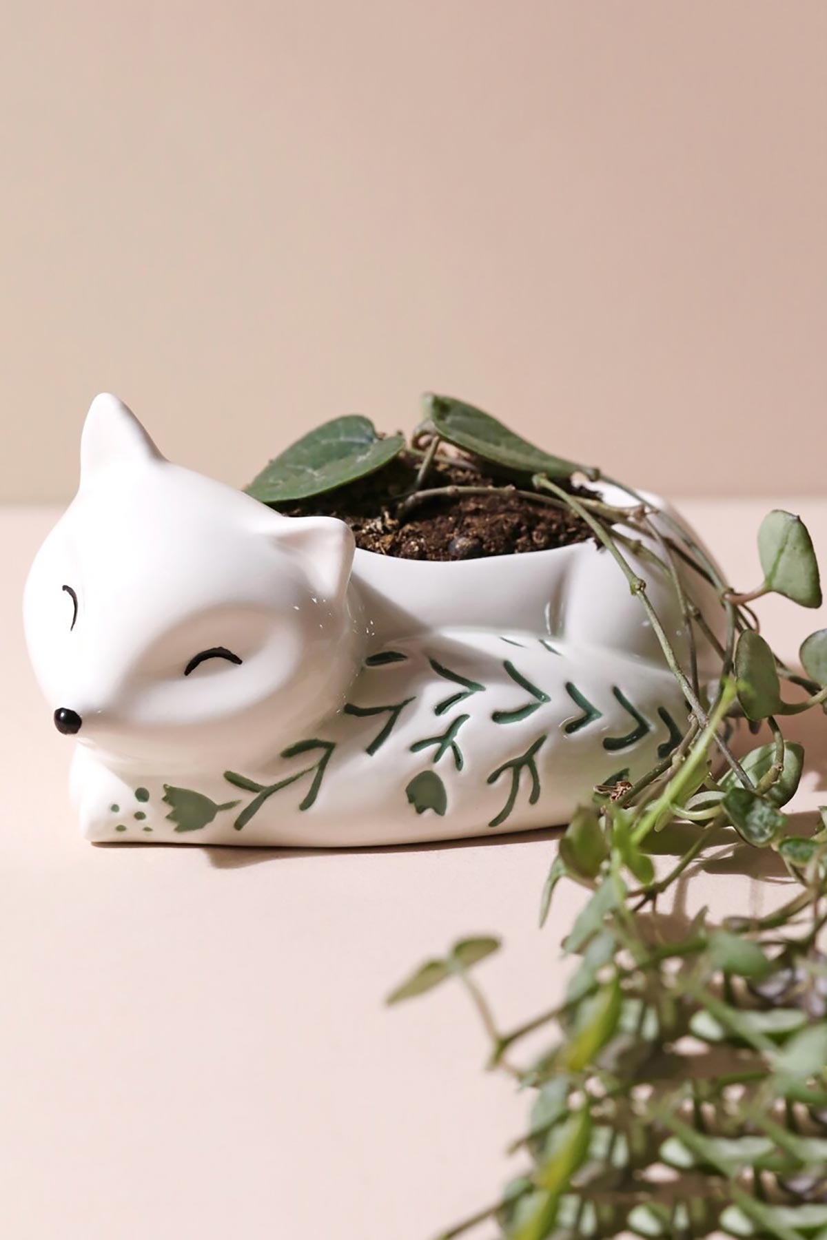 Sleeping fox planter holding small plant