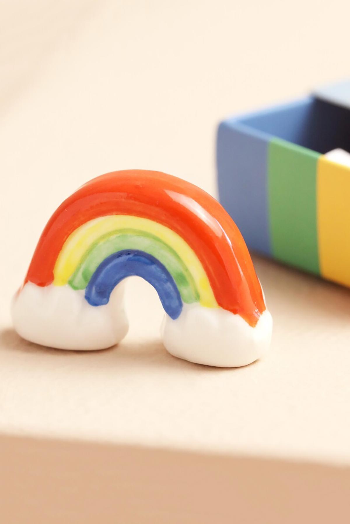 Ceramic rainbow token displayed outside matchbox