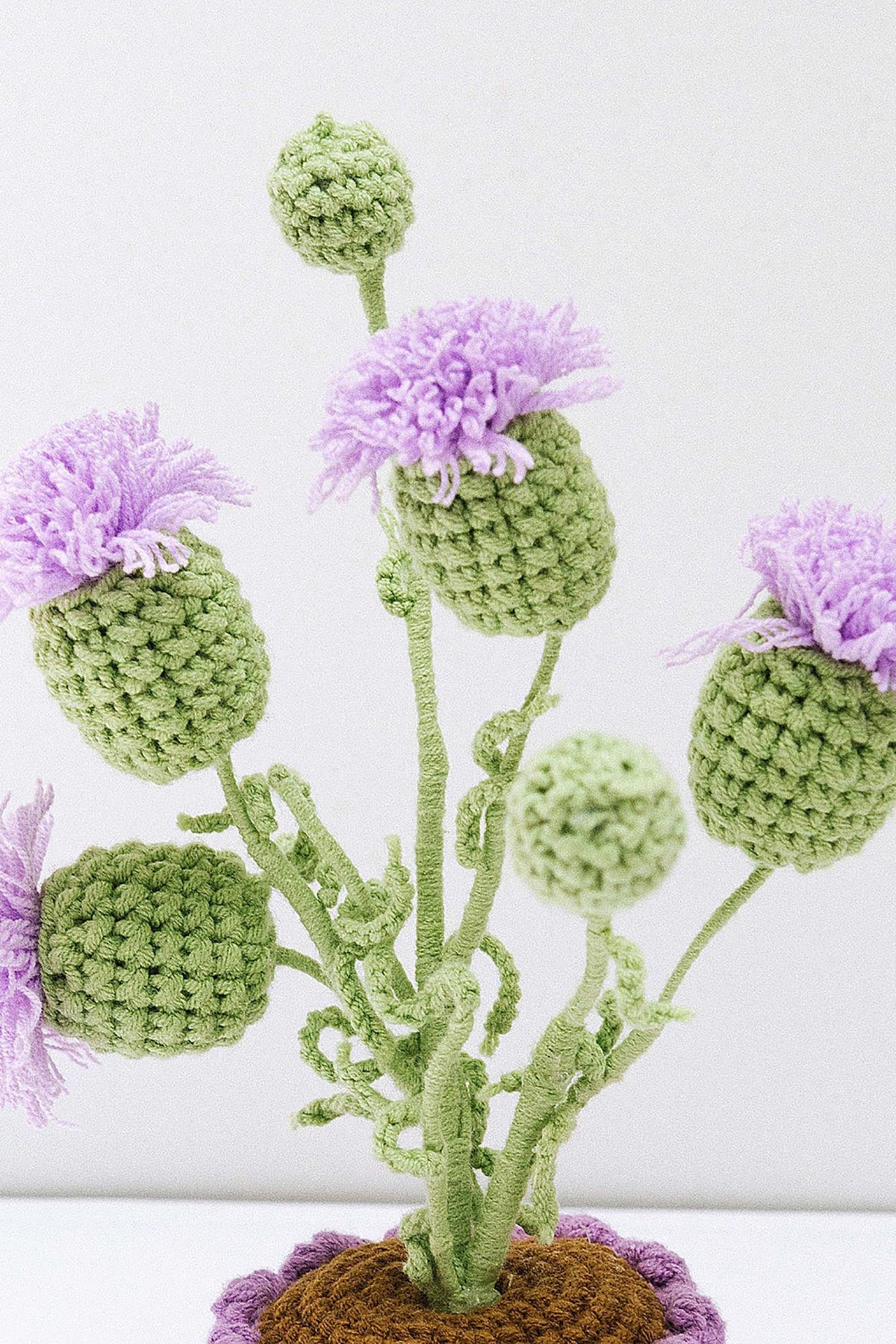 Crochet thistle detail showing green stems and lilac petals