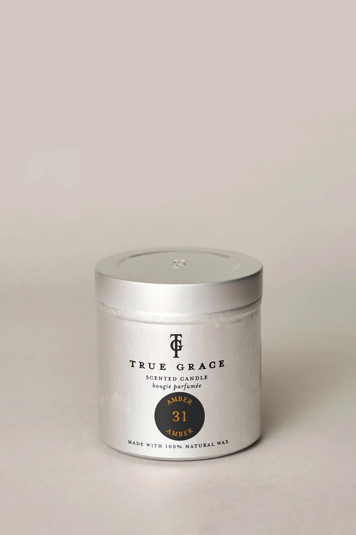 True Grace Amber Tin Candle styled as warm home fragrance