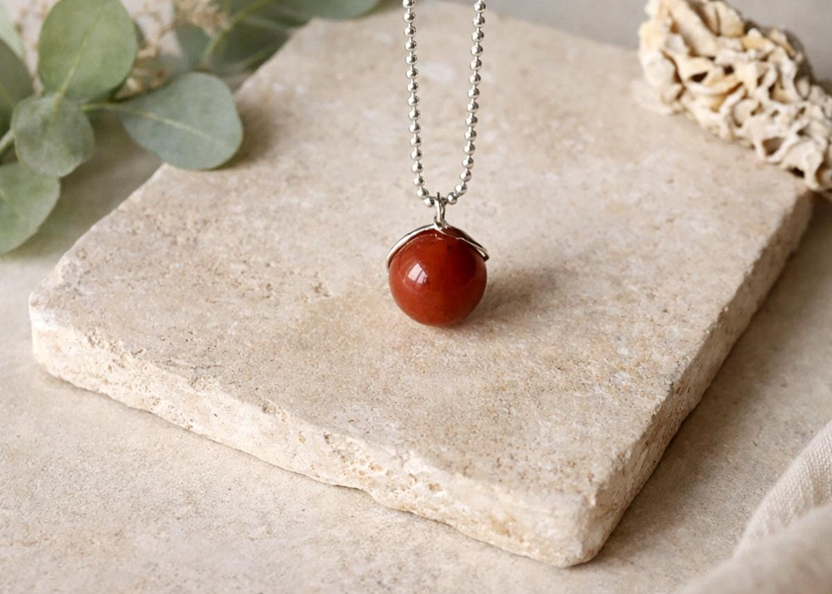 Twigs & Stones red jasper pendant necklace on a stone tile