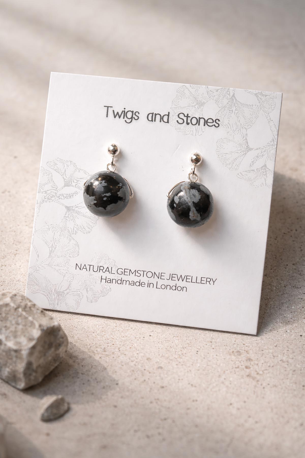 Close-up of snowflake obsidian gemstone stud earrings