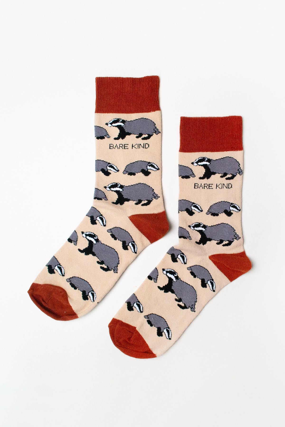Pair of beige badger bamboo crew socks with rust cuffs and toes flat lay — Urban Wild