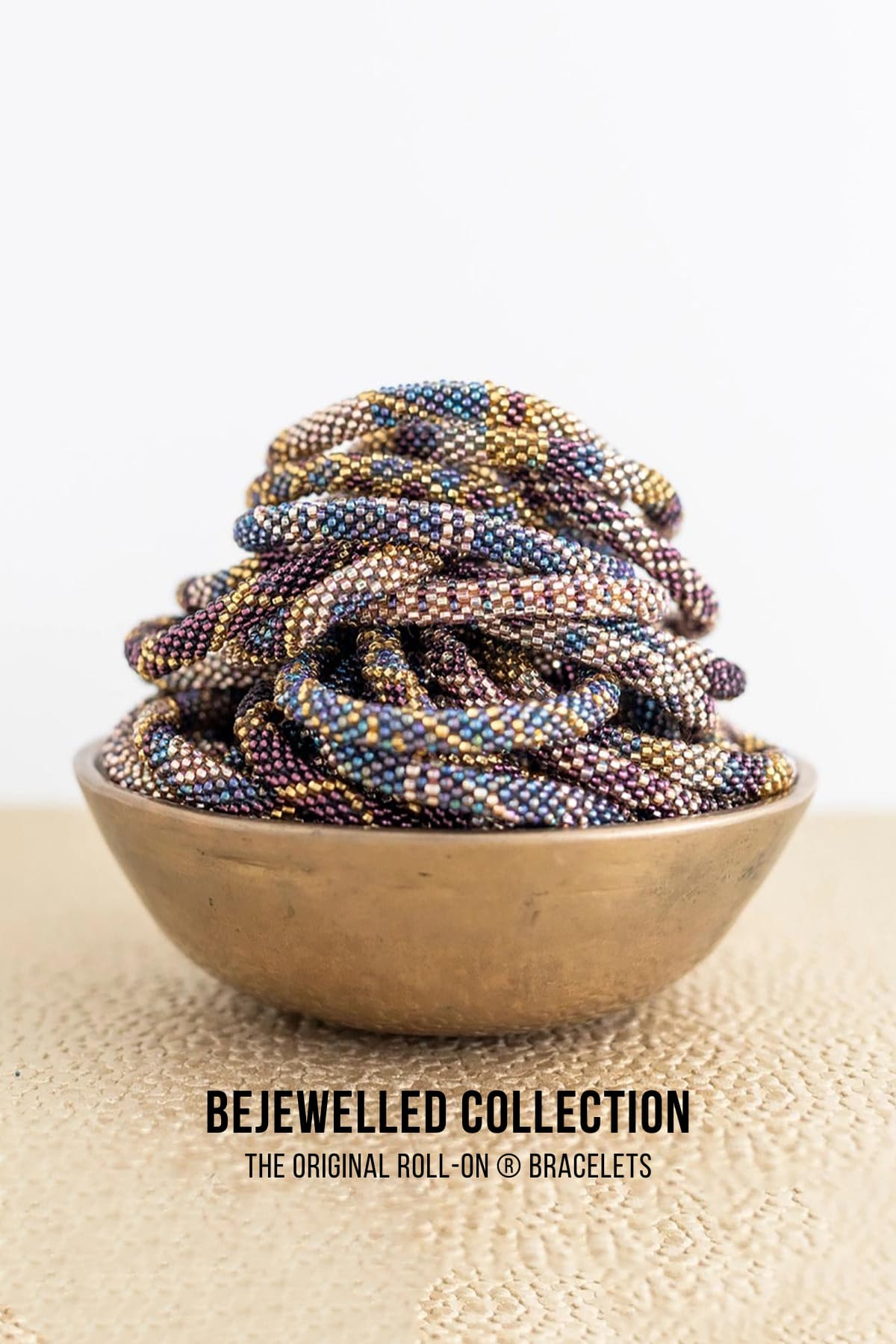 Bejewelled beaded Roll-On bracelets in burgundy gold and violet displayed in brass bowl — Urban Wild