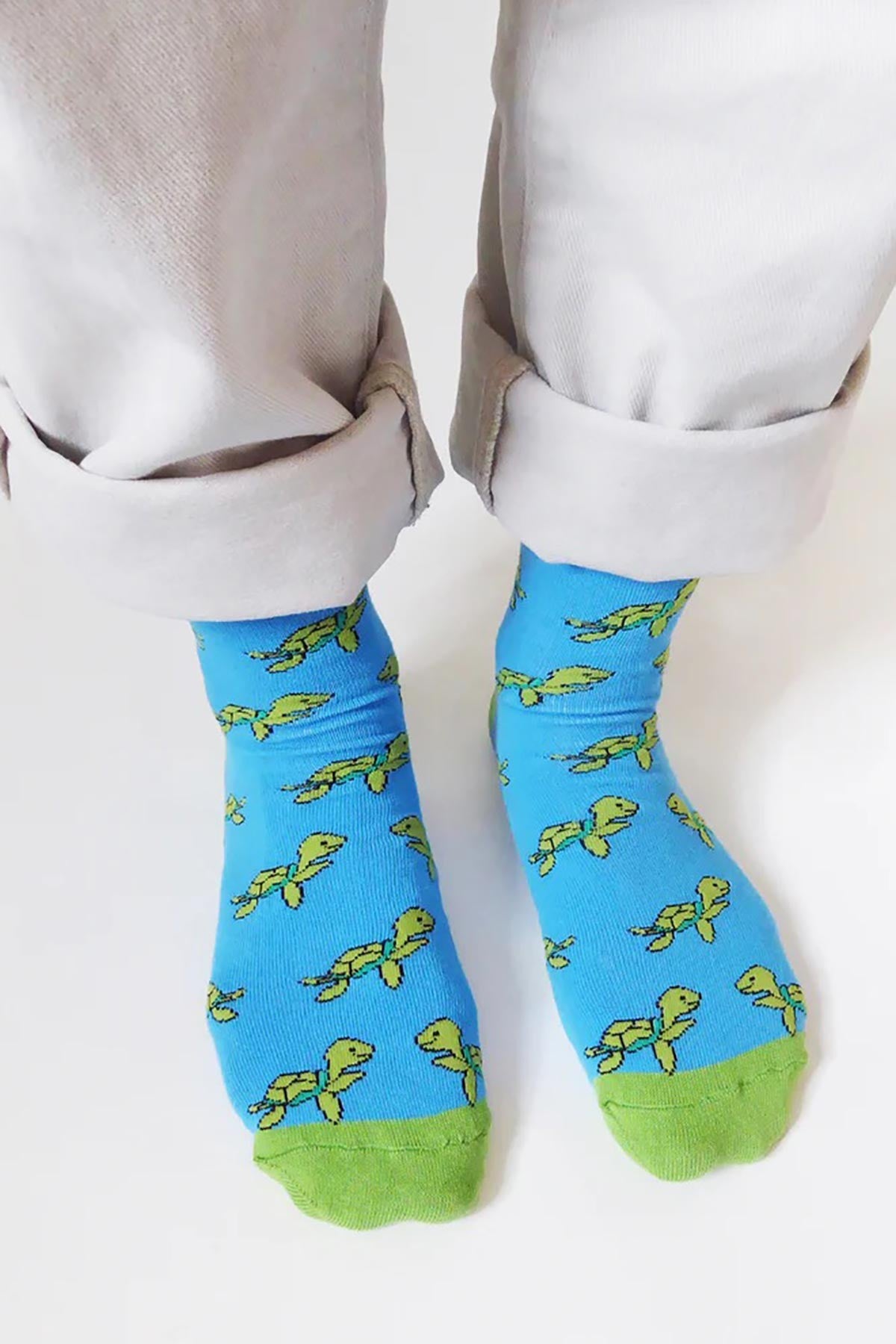 Blue bamboo turtle socks shown on feet with rolled cream trousers — Urban Wild