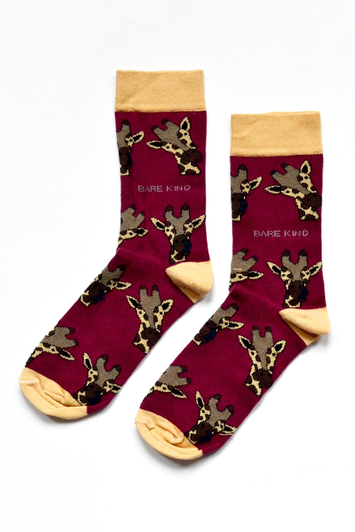Pair of burgundy bamboo crew socks with giraffe motifs and yellow toe and heel — Urban Wild