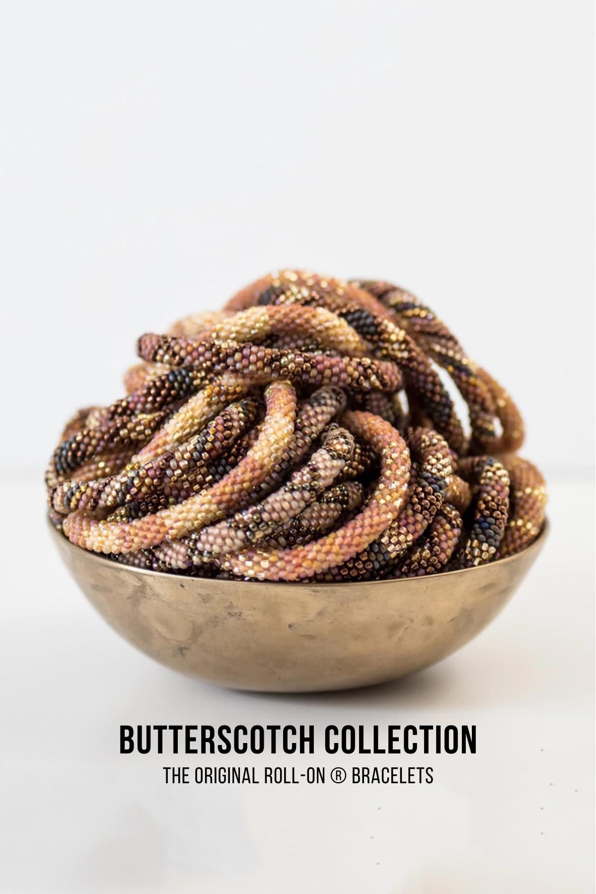 Butterscotch beaded Roll-On bracelets in caramel and gold tones gathered in a brass bowl — Urban Wild