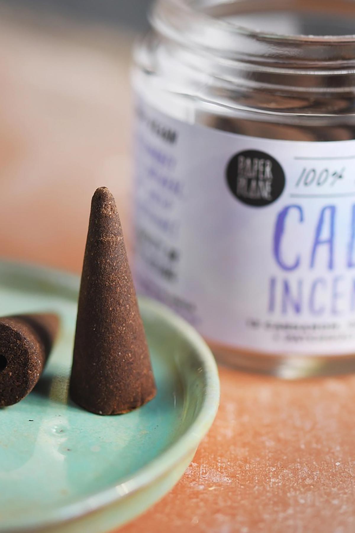 Close up of natural cardamom cedarwood and patchouli incense cone on ceramic dish — Urban Wild