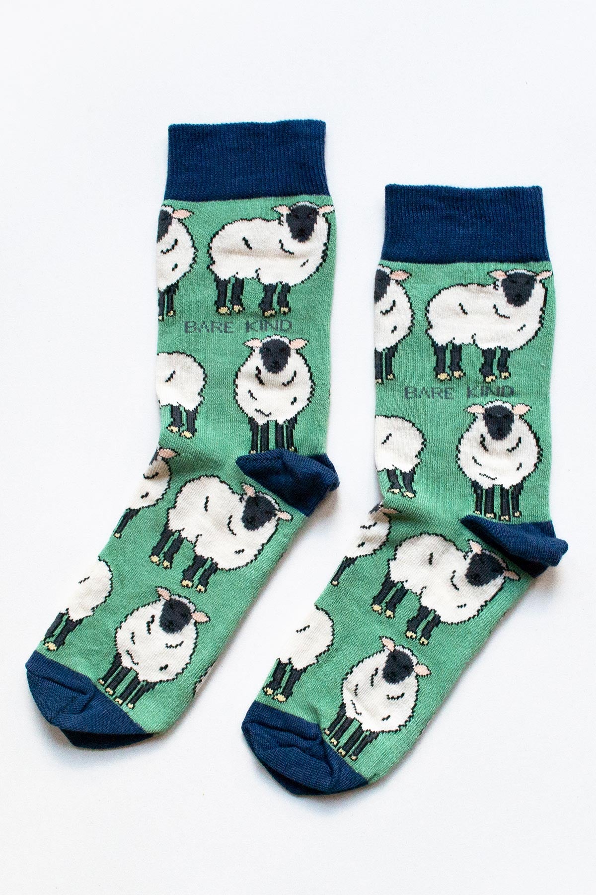 Pair of green bamboo crew socks with all over sheep illustration and navy cuffs - Urban Wild