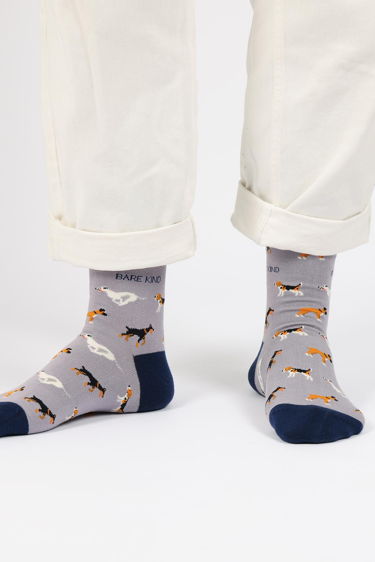 Grey bamboo crew socks with navy cuffs and dog print by Bare Kind, worn with cream trousers — Urban Wild