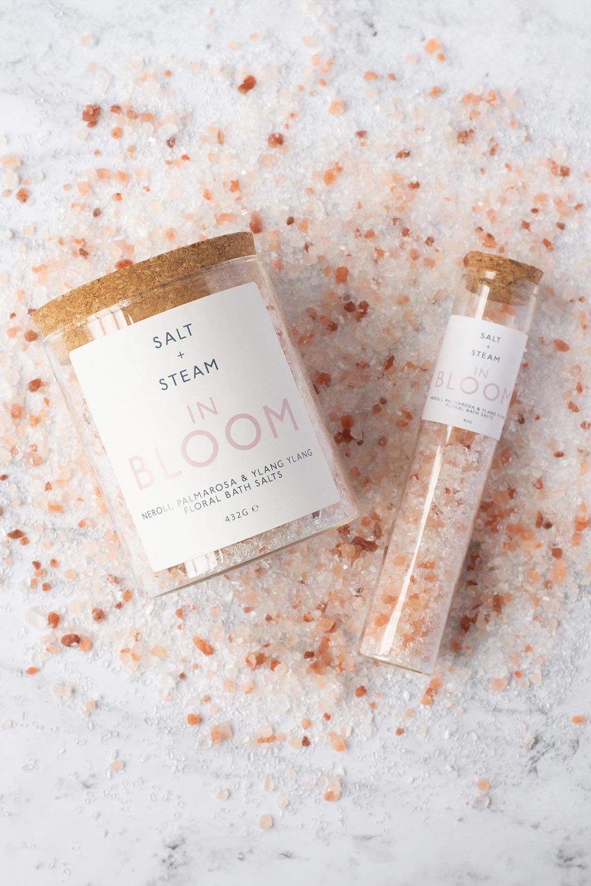 In Bloom bath salts jar and bath shot with pink Himalayan salt scattered on marble — Urban Wild