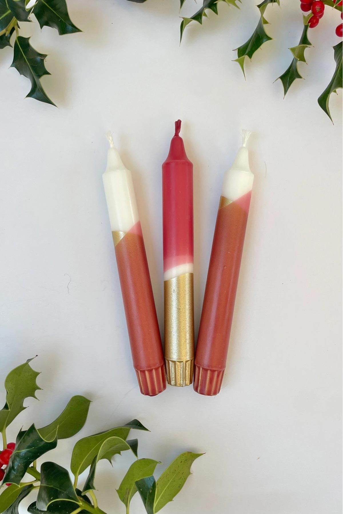Red and gold taper candles lit on mantelpiece for festive glow — Urban Wild