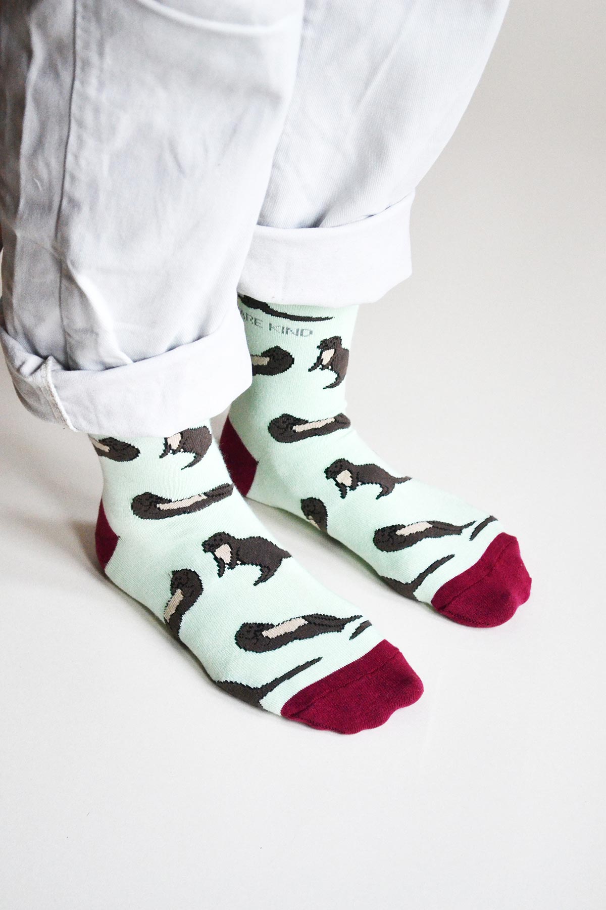 Mint green and burgundy bamboo otter socks worn with rolled white trousers — Urban Wild