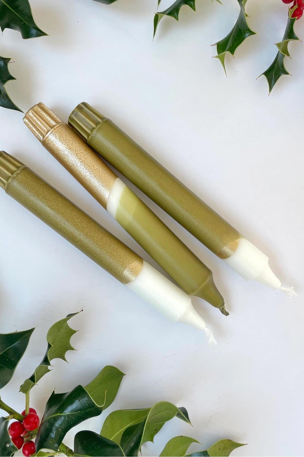 The Singing Rabbit olive green gold taper candles lit for dinner — Urban Wild