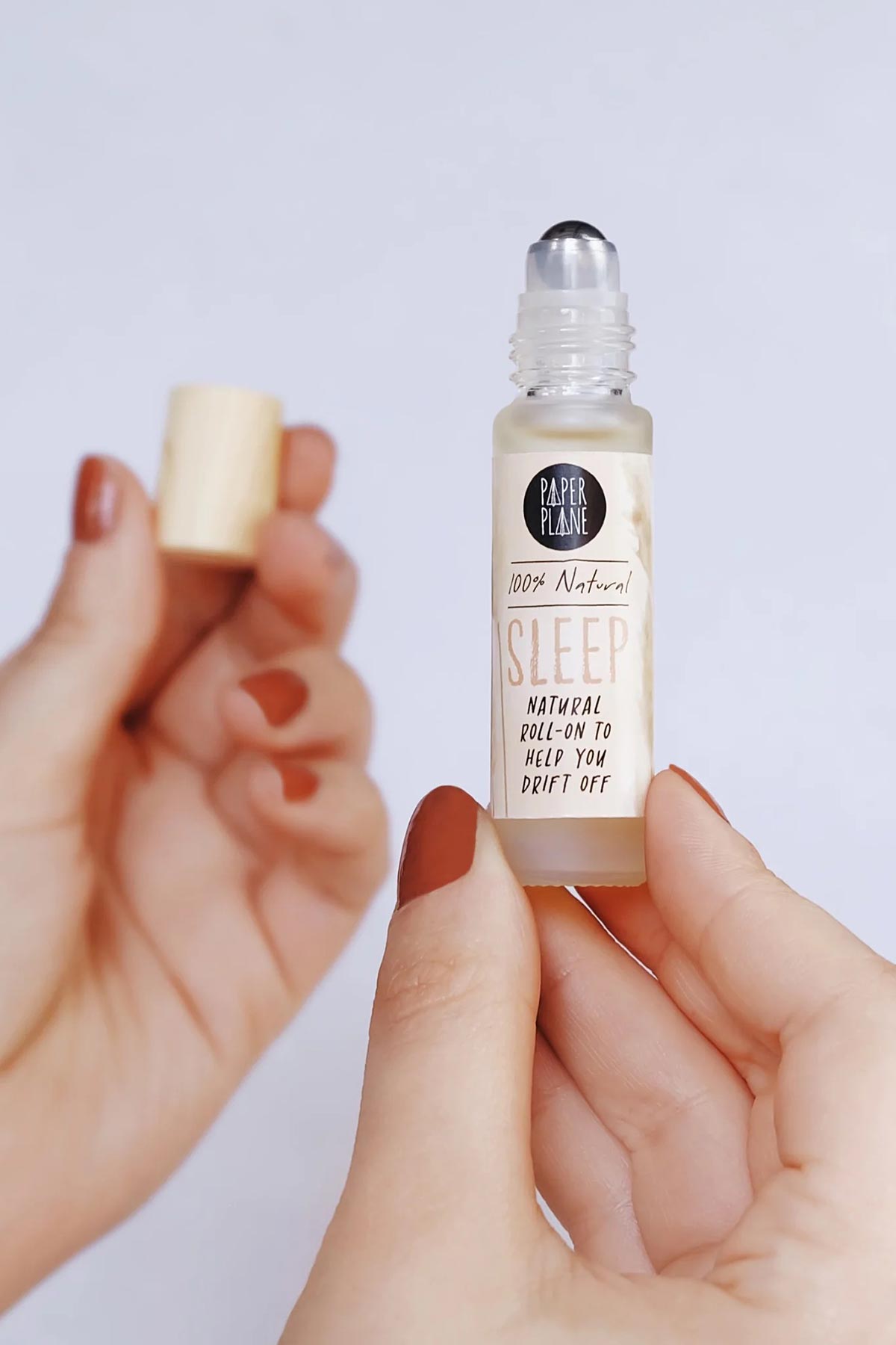 Hands holding natural sleep roller oil and wooden cap — Urban Wild