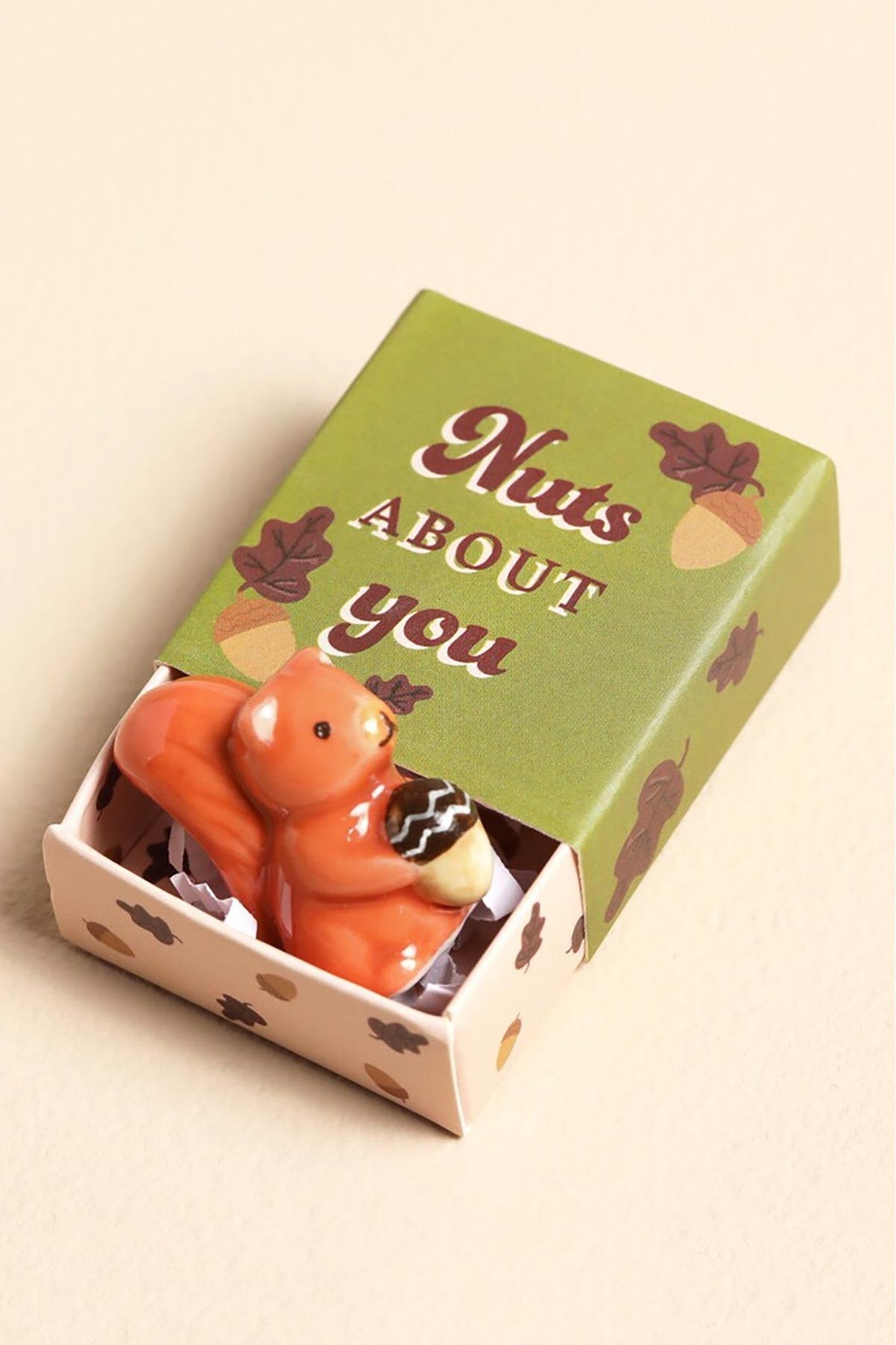 Tiny orange ceramic squirrel token holding an acorn in giftable matchbox — Urban Wild