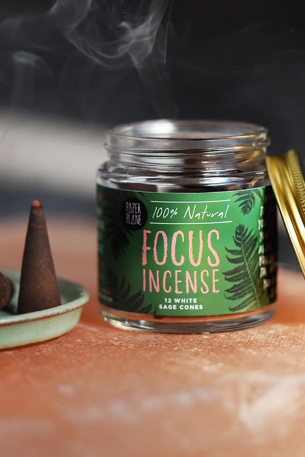 White sage focus incense cone burning with smoke beside open Paper Plane jar — Urban Wild